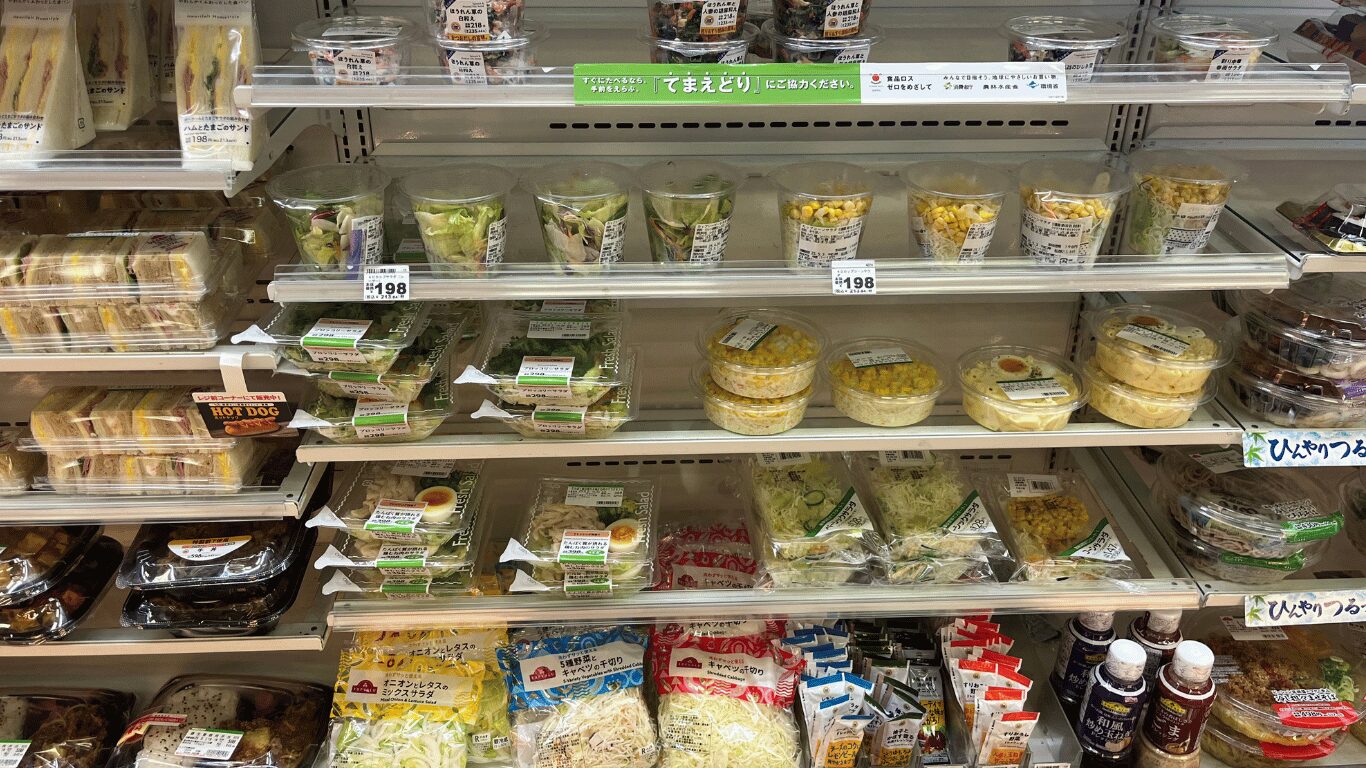コンビニに並ぶサラダやサンドイッチなどの軽食コーナー。外食費を抑えるための節約対策として便利な選択肢。