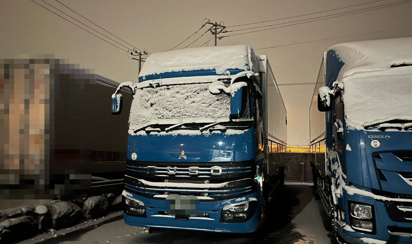 東北の冬に雪が積もった長距離トラック
